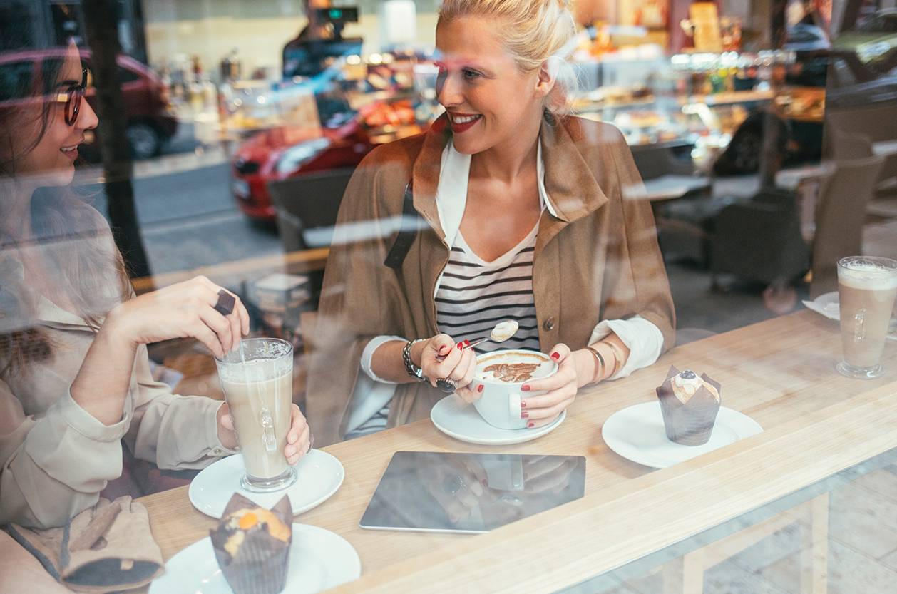 Smiling Women Sitting at a Coffee Shop