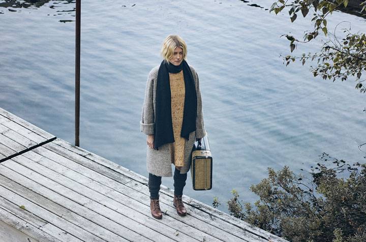 PHOTOGRAPH BY MACKENZIE DUNCAN. WovenWears gold dress (wovenwares.xyz, $355) and WovenWears wool coat (Hold General Store, $300), both woven by May Cloth Studio; black linen wrap by Hendrik Lou (hendriklou.com or in store at Open House, $120); grey scrunch socks (Heart & Sole Shoes, $27); camel Sienna boots (Heart & Sole Shoes, $170)