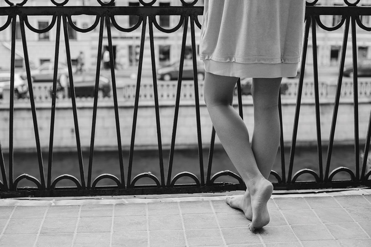 Woman Standing On A Balcony.