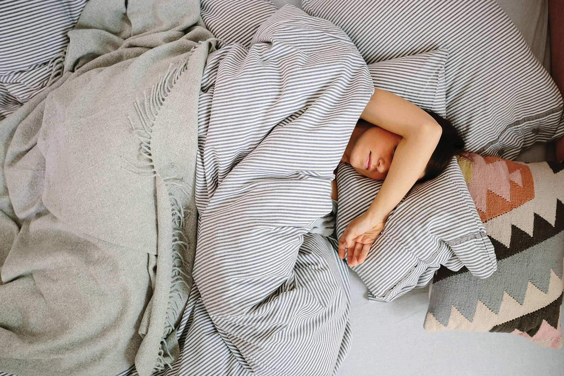 Young Woman Sleeping In Bed In Morning
