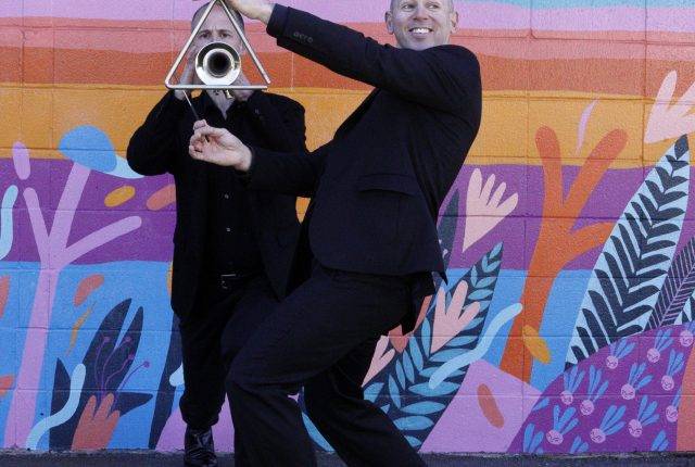 Victoria Symphony musicians in front of a colourful mural