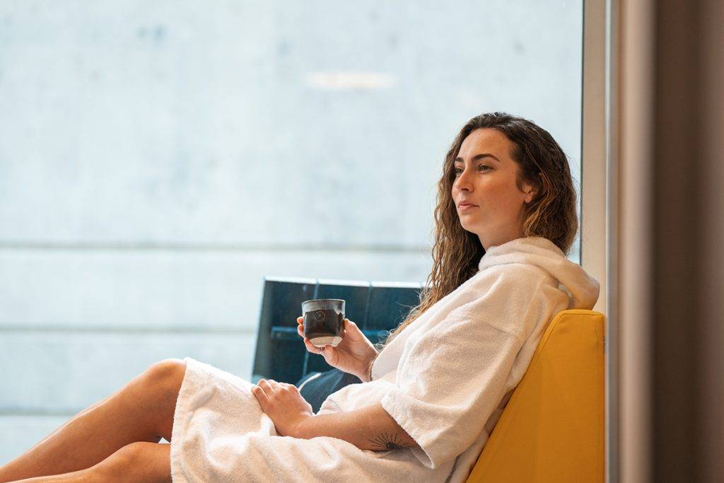 Woman in robe relaxing at RITUAL Nordic Spa