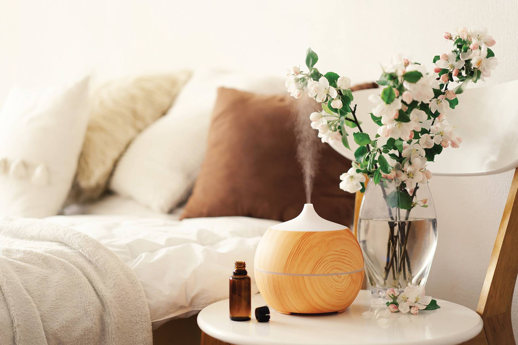 Aromatherapy Concept. Aroma oil diffuser on chair against in the bedroom. Air freshener.