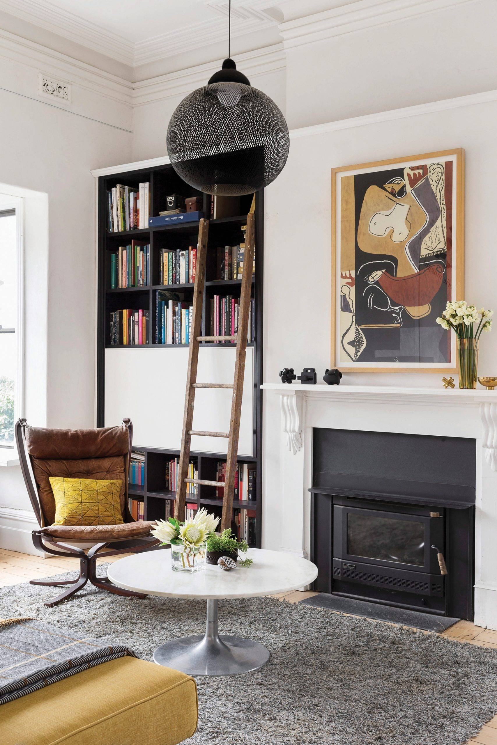Coffee table and classic chair in front of fireplace and bookcase