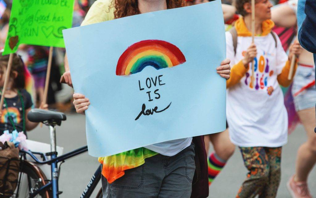 Victoria Pride Parade goer holds up a sign that says love is love.