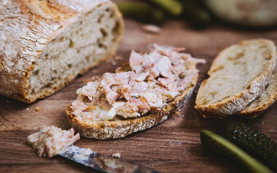 Pate being spread on crusty bread
